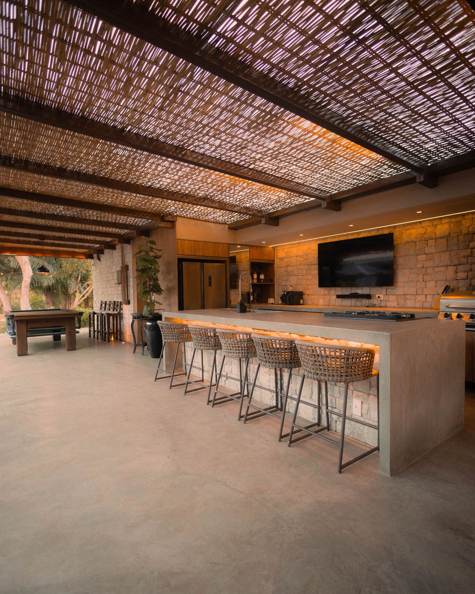 Outdoor kitchen and bar under a shade structure — design inspiration