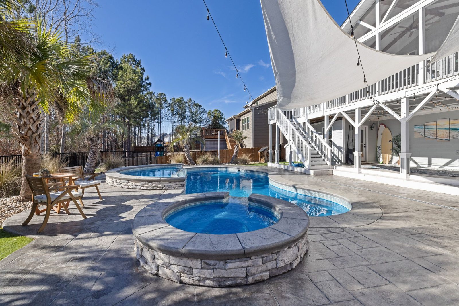 Freeform pool paired with a raised stone spa โ design inspiration